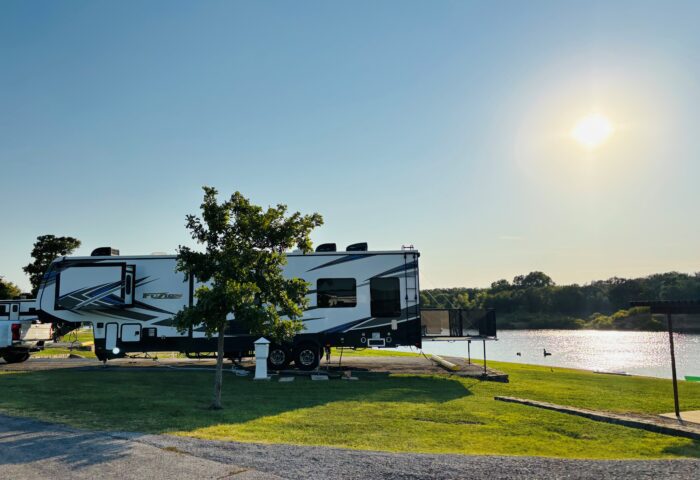 A fifth wheel RV camping near the lake