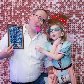 Dad and daughter making silly faces in photo booth