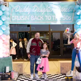 Dad and daughter with entrance banner