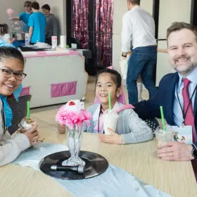 Dad and daughters enjoying milkshake